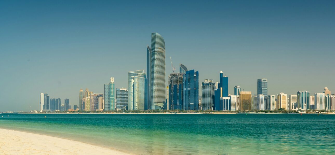 Abu Dhabi skyline seen across the water from a beach