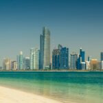 Abu Dhabi skyline seen across the water from a beach